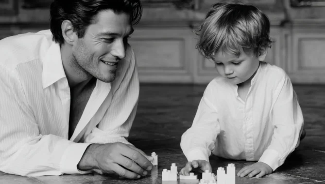 black white classy photography of father and son on floor playing with wooden bricks