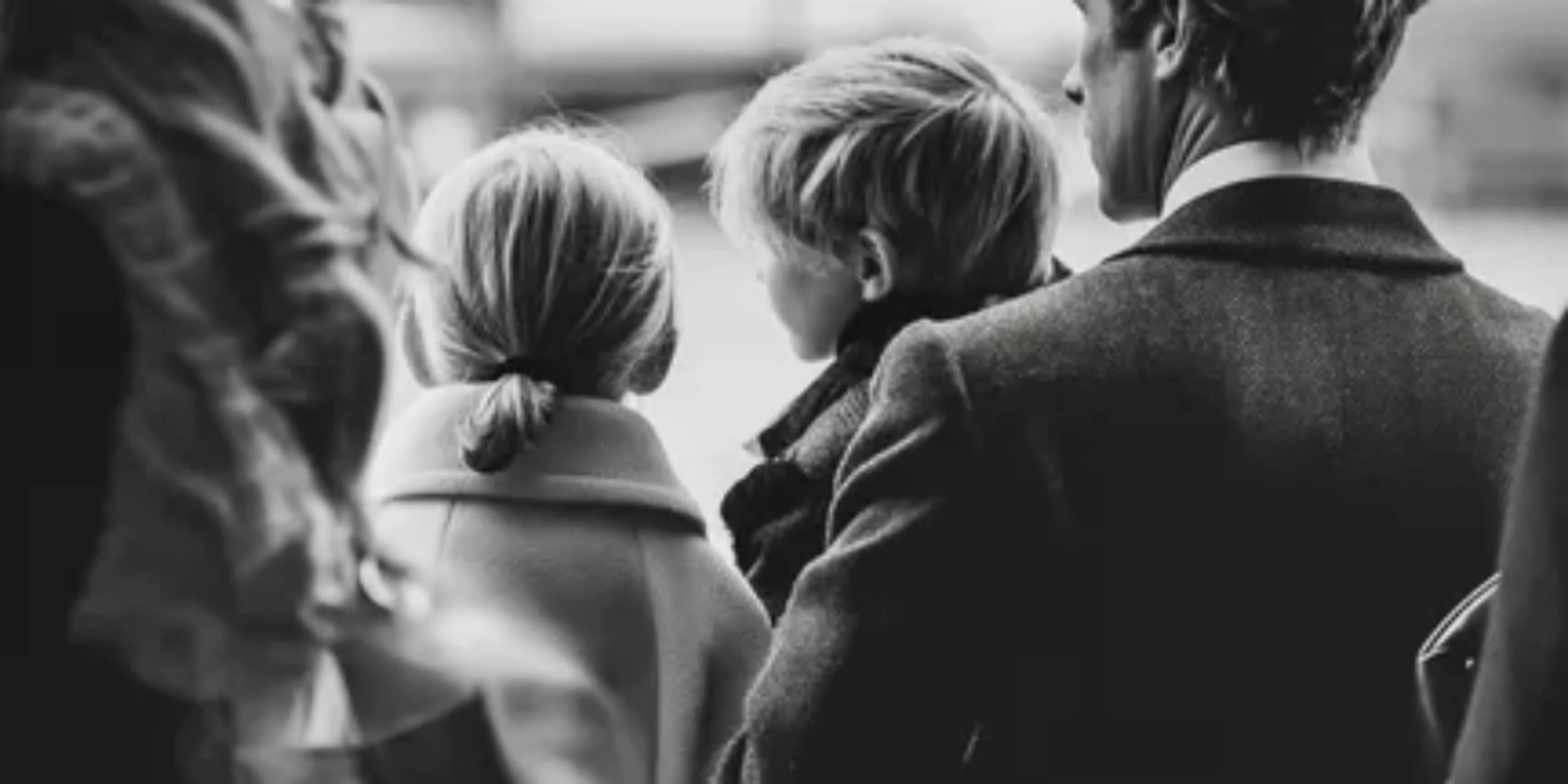 photograph of dad holding son at airport with daughter next to him