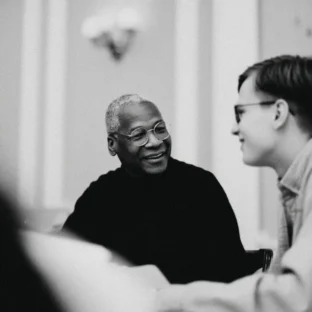 An older tutor and student engaging in conversation