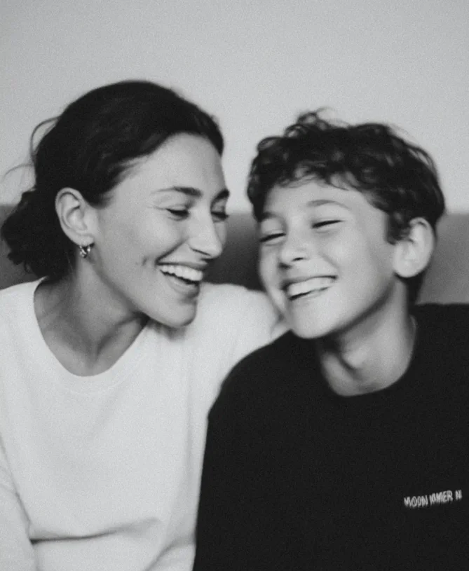 Mother and son looking happy on sofa