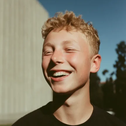 Happy teenage boy smiling with eyes slightly closed