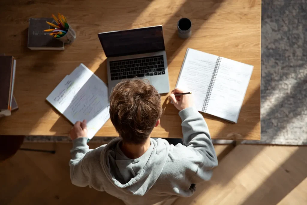 Photo top down angle of boy studying at desk at home