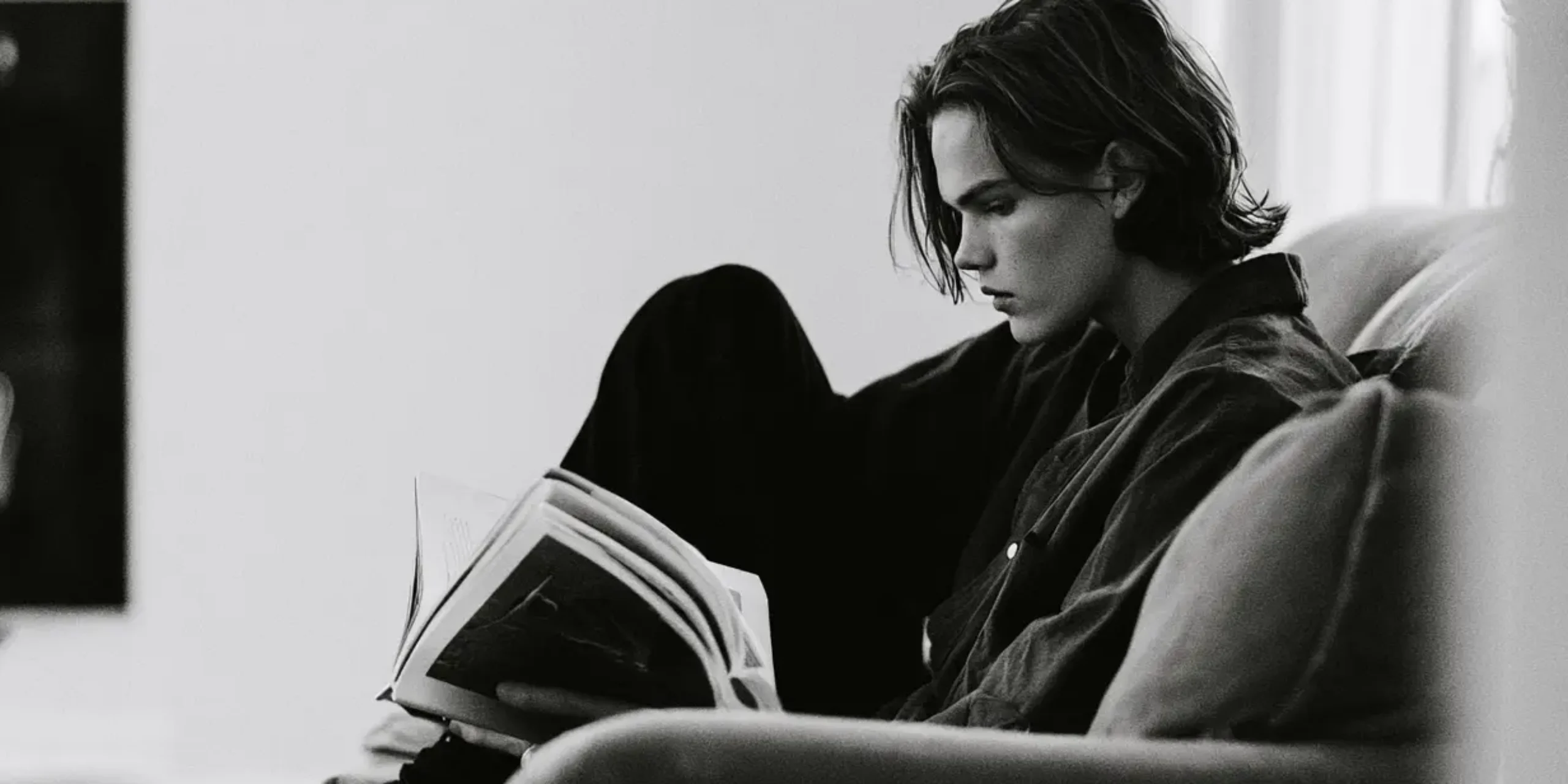 Teenager reading at home, black and white